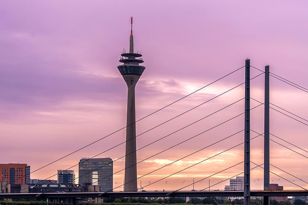 Augen lasern in Düsseldorf: Skyline der Brücke und des Funkturms von Düsseldorf am Abend.